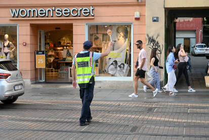 Policajac zaustavlja vozila Saobraćajni policajac na ulici reguliše saobraćaj. Policajac zaustavlja vozila. Zagreb, Hrvatska.