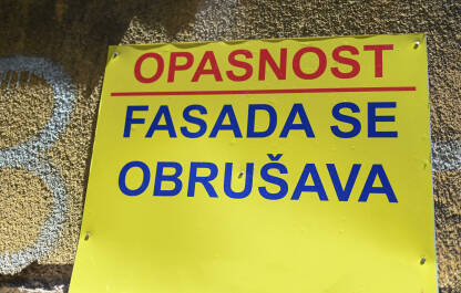 Opasnost, fasada se obrušava Znak upozorenja na zgradi u gradu: Opasnost, fasada se obrušava.