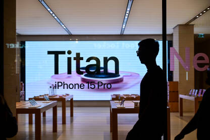 Izlog Apple trgovine. Novi iPhone 15. Izlog Apple trgovine u gradu noću. Reklama za novi iPhone 15. Titanium. Prodavnica pametnih telefona reklamira novi model telefona.