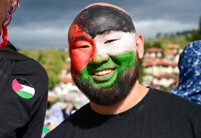 Čovjek sa palestinskom zastavom preko lica na protestima. Čovjek sa palestinskom zastavom preko lica na demonstracijama. Protest podrške narodu Palestine. Solidarnost. Podrška narodu Gaze.