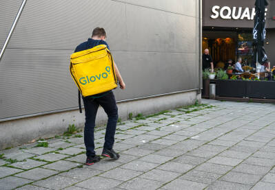 Glovo dostavljač hrane Glovo dostavljač sa torbom na leđima. Dostava hrane u gradovima.