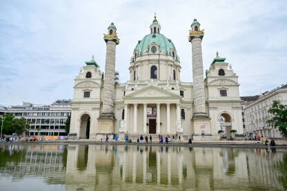 Beč, Austrija: Ljudi ispred crkve. Beč, Austrija: Ljudi ispred crkve. Fontana. Turisti istražuju grad. Karlskirche ili Rektoratska crkva sv. Karla Boromejskog.