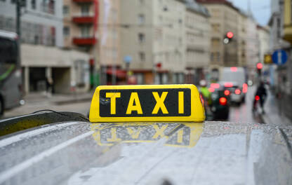 Taxi znak na krovu automobila Taxi znak na krovu automobila. Taksi na ulici. Taxi stajalište u gradu. Prijevoz.