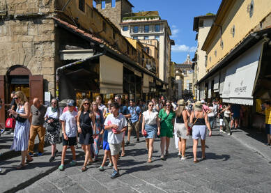 Firenca, Italija: grupa turista na mostu Vecchio. Firenca, Italija: grupa turista na mostu Vecchio. Ljudi šetaju gradom. Historijske zgrade u centru grada.