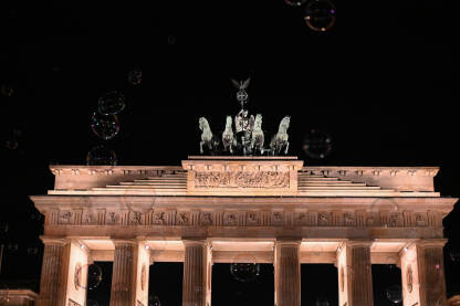 Berlin, Njemačka: Brandenburška vrata uokvirena  balonima od sapunice. Simbol Berlina i njemačke podjele tokom ere Hladnog rata. Brandenburška vrata noću.