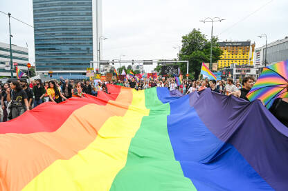 Ljudi nose veliku duginu zastavu Sarajevo, Bosna i Hercegovina, 24. juna 2023.: Povorka ponosa na ulicama glavnog grada BiH. Protestna šetnja. LGBTIQ Pride.