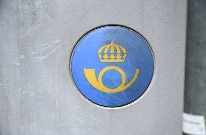 Logo Švedske pošte na javnom poštanskom sandučiću u Švedskoj. Logo švedske poštanske službe prikazan na uličnom poštanskom sandučiću.