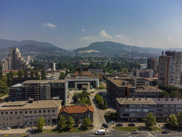 Zenica Grad Zenica, u sredini zgrada Bosanskog narodnog pozorišta Zenica, lijevo u pozadini Lamela, desno naprijed zgrada Gradske uprave i MUP-a ZDK, a u pozadini desno zgrada RMK Prometa, sjedište Vlade ZDK