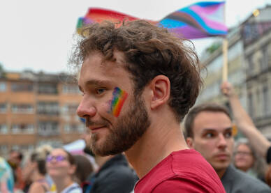 Povorka ponosa 2023 Mušarac sa zastavom duginih boja, nacrtanom na licu. Učesnik protesta za prava LGBTIQ zajednice. Sarajevo, 24. jun 2023