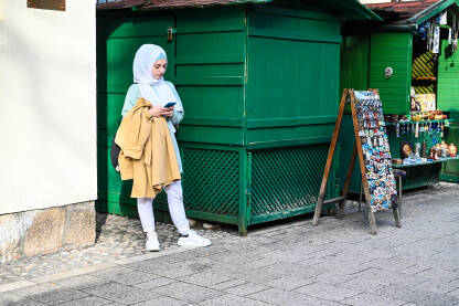 Djevojka s maramom na ulici Djevojka s maramom na glavi. Mlada Muslimanka u gradu. Tradicionalna nošnja.
