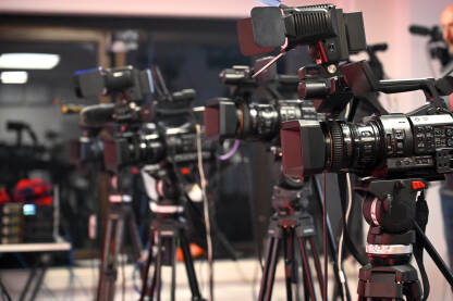 Kamere na konferenciji za novinare. Novinarstvo. Kamere na konferenciji za novinare. Snimanje i praćenje medijskog događaja video kamerom. Novinarstvo. Profesionalni snimatelj snima intervju.