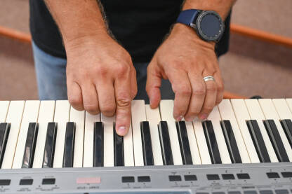 Muzičar svira klavijature Muškarac svira piano. Muzičar svira električni piano. Muzički instrument.