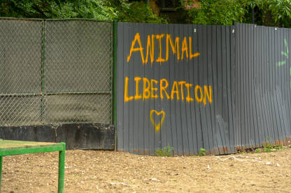 Natpis "Sloboda životinjama" na ogradi. Aktivisti za prava životinja. Veganstvo.