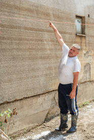 Čovjek pokazuje na kojoj je visini se izlila rijeka nakon katastrofalnih poplava 2014. godine u BiH.