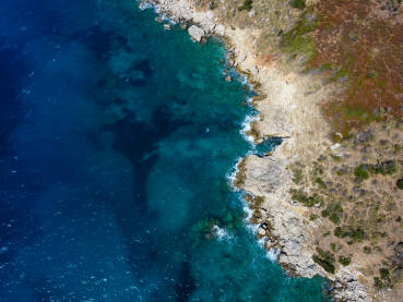 Prekrasna prirodna stjenovita plaža i more ljeti. Valovi se lome na plaži, snimak dronom.