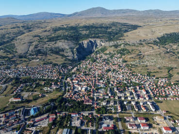 Grad Livno, BiH, panorama grada, brdo Bašajkovac i planina Cincar. Grad Livno, BiH, panorama grada, brdo Bašajkovac i planina Cincar. Panoramski pogled na zgrade, kuće i ulice, snimak dronom.