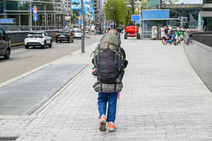 Čovjek sa velikim ruksakom šeta gradom Čovjek sa velikim ruksakom šeta gradom. Turist istražuje grad. Backpacker.