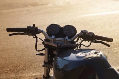 Crni motor na cesti sa zalaskom sunca.