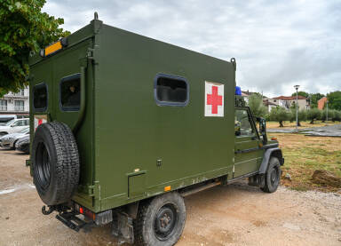 Vojno ambulantno vozilo Vojno ambulantno vozilo na poligonu. Simbol crvenog križa / krsta na autu.