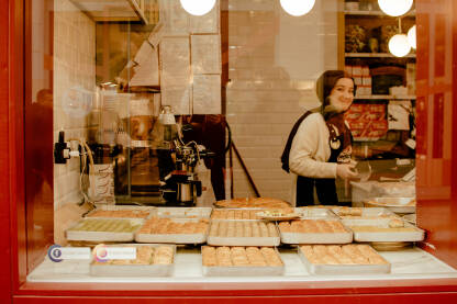 Baklava shop u Sarajevu Nasmijana djevojka prodaje baklave. Razne vrste baklava. Baklava shop u Sarajevu. Trgovac. Baklave u izlogu.