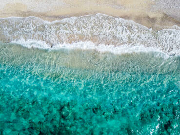 Prekrasna tropska plaža sa žutim pijeskom. Morski valovi na pijesku uz obalu, snimci dronom. Obala mora. Pješčana plaža ljeti.