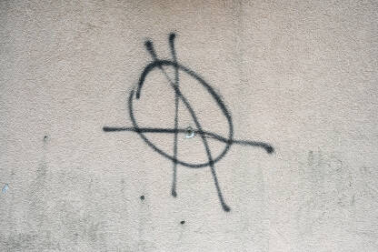 Simbol anarhije na zidu Znak anarhije nacrtan na zidu. Grafit u gradu. Simbol anarhije.