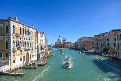 Građevine i kanal u Veneciji, Italija Venecija, Italija: Historijske građevine uz riječni kanal u centru grada. Popularno turističko odredište. Čamci i gondole na vodi.