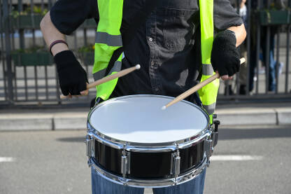 Djevojka svira doboš. Muzičarka svira bubnjeve. Žena svira doboš tokom protesta.