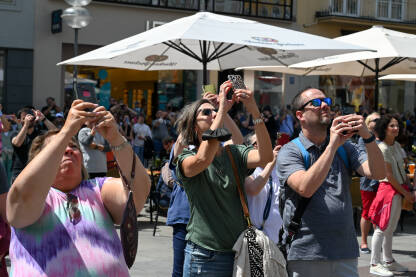 Ljudi fotografišu i snimaju mobilnim telefonima Ljudi fotografišu i snimaju mobilnim telefonima u centru grada. Turisti sa mobilnim telefonima u rukama.