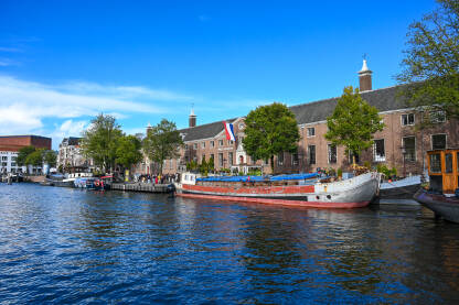 Amsterdam, Nizozemska: Zgrade uz rijeku. Amsterdam, Nizozemska: Vožnja turističkim brodom kroz kanale. Zgrade uz rijeku. Čamci na vodi.