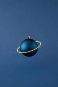Plava božićna kuglica Plava božićna kuglica s neonskim prstenom na plavoj pozadini. Planet Saturn.