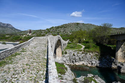 Stari kameni most iznad rijeke. Mesi most na rijeci Kir, Skadar, Albanija. Stari kameni most iznad rijeke. Voda teče ispod mosta. Mesi most na rijeci Kir, Shkoder, Albanija, sagrađen u 18 vijeku. Otomanska arhitektura. Turistička atrakcija.