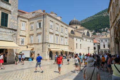 Dubrovnik, Hrvatska: Grupa turista u starom gradu. Ljudi šetaju centrom grada. Stare zidine i zgrade u Dubrovniku. Popularno turističko odredište na Jadranskom moru. Stradun.
