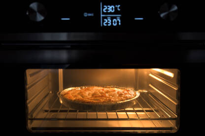 Pečenje pite u električnoj pećnici sa digitalnim displejom i kontrolama.