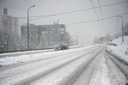 Vožnja automobilom po snijegu u gradu zimi. Vožnja automobilom po snijegu u gradu zimi. Opasan zimski put. Zaleđeni putevi. Pahuljice padaju.