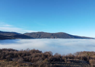 Magla i oblaci prekrivaju dolinu, snimak dronom. Zagađenje zraka. Inverzijom oblaka. Let iznad oblaka.