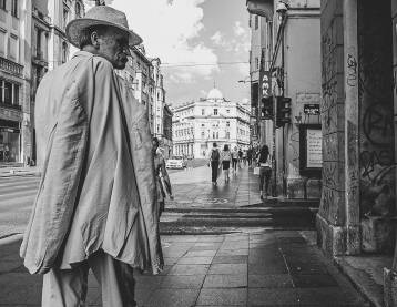 Stariji čovjek na ulici Stariji čovjek u odijelu stoji na ulici u Sarajevu razgleda knjige u izlogu