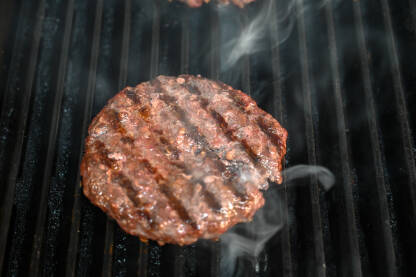 Prženje hamburgera Prženje hamburgera. Pljeskavica na roštilju. Ukusno mljeveno meso na roštilju.