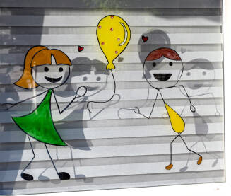 Crteži na prozoru dječjeg vrtića, djeca se igraju Crteži na prozoru dječjeg vrtića. Ilustracije i crteži djece.