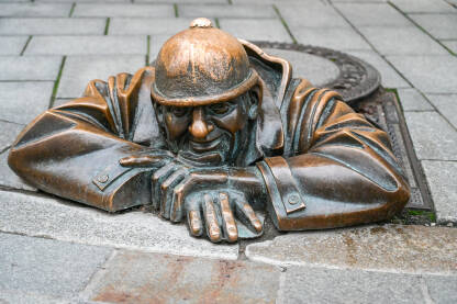 Bratislava, Slovačka, statua radnika. Bratislava, Slovačka: Cumil kanalizacioni radnik, jedna od najčešće fotografisanih statua. Statua radnika kanalizacije koji izlazi iz šahta. Spomenik u starom gradu.