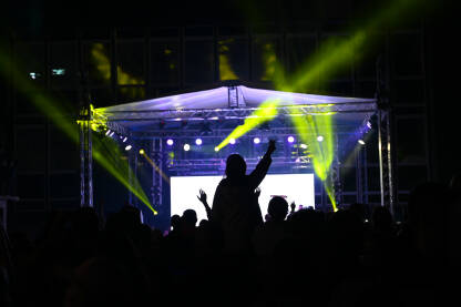 Publika ispred bine Publika ispred bine na festivalu. Ljubitelji muzike na rock koncertu. Rasvjeta i osvjetljenje pozornice tokom muzičkog koncerta.