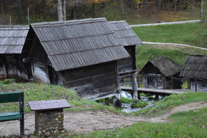 Mlinčići u Jajcu Drveni mlinčići u Jajcu koji su služili mljevenju žita. Na slici je vidljv dio zelene klupe i stol pored male staze.