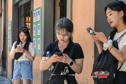 Djevojke koriste mobilne telefone u gradu. Djevojke koriste mobilne telefone u gradu. Turisti istražuju grad. Djevojke surfaju internetom i pišu poruke.