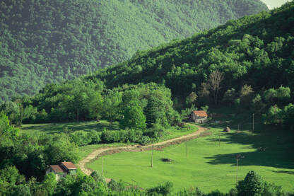 Makadamski put koji vodi ka usamljenoj kuci u selu podno Manjače. Život na selu. Udaljene seoske kuće.
