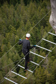 Planinarenje na via ferrata Planinar prelazi most na via ferrata Sokolov put na Crvenim stijenama na Romaniji.