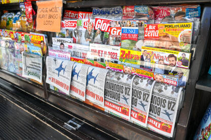 Dnevne novine i sedmični novine iz Bosne i Hercegovine i regiona izložene na lokalnom kiosku. Razne štampane novine i časopisi na polici kioska. Dnevni avaz i Oslobođenje.