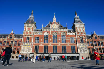 Amsterdam, Nizozemska: Glavna željeznička stanica. Putnici ispred stanice.
