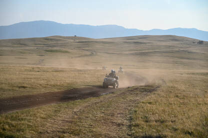 Mnogo kvadova diže prašinu na planini. Turisti voze kvadove. Quad.