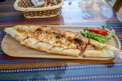 Ukusni pide poslužen na stolu u restoranu. Ukusni pide poslužen na stolu u restoranu. Tradicionalna hrana iz Turske. Pide je punjeni hljeb u turskoj kuhinji. Brza hrana.