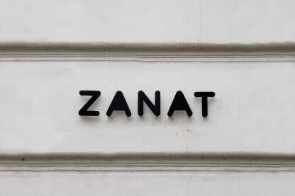 Zanat, natpis na zidu Logo Zanat na bijeloj fasadi na zanatskoj radnji u Sarajevu.